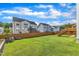 A spacious backyard with a green lawn, wood fence, mature trees, and a view of surrounding homes at 508 White Oak Branch Ln, Apex, NC 27523