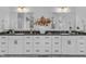 Bathroom featuring white cabinetry, dual sinks, and decorative floral accents at 508 White Oak Branch Ln, Apex, NC 27523