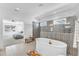 Inviting bathroom with soaking tub, stylish tile accent wall, and lots of natural light at 508 White Oak Branch Ln, Apex, NC 27523