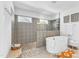 Bright bathroom featuring a soaking tub, a glass enclosed shower, and patterned tile walls at 508 White Oak Branch Ln, Apex, NC 27523
