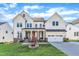 Stunning two-story home featuring a brick-accented porch, two-car garage and manicured lawn at 508 White Oak Branch Ln, Apex, NC 27523