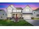 Beautiful two-story home with manicured lawn, brick accents, and a charming front garden at twilight at 508 White Oak Branch Ln, Apex, NC 27523