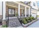 Inviting front porch featuring brick accents, white columns, and a welcoming seating area at 508 White Oak Branch Ln, Apex, NC 27523