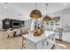 Bright, open kitchen with large island, modern lighting, stainless appliances, and seamless flow to the dining and living areas at 508 White Oak Branch Ln, Apex, NC 27523