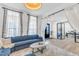 Bright living room with large windows, a blue sofa, and elegant curtains at 508 White Oak Branch Ln, Apex, NC 27523