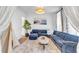 Cozy living room with a blue sofa, decorative painting, and soft carpet at 508 White Oak Branch Ln, Apex, NC 27523