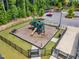 Aerial view of a playground with slides, climbing structures, and seating surrounded by a black metal fence at 508 White Oak Branch Ln, Apex, NC 27523