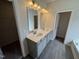 Elegant bathroom with double vanity, modern lighting, and sleek tile flooring at 51 Commons Cir, Clayton, NC 27520