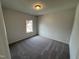 Bright bedroom with neutral walls, plush carpeting, and a large window that provides natural light at 51 Commons Cir, Clayton, NC 27520
