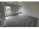 Bright bedroom with neutral walls, plush carpeting, and two windows that provide ample natural light at 51 Commons Cir, Clayton, NC 27520