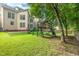 Lush backyard featuring a playset, mature trees, and manicured lawn at 5102 Highcroft Dr, Cary, NC 27519