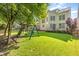 Expansive backyard with a well-maintained lawn, mature trees, and a playset at 5102 Highcroft Dr, Cary, NC 27519