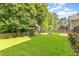 Spacious backyard featuring lush green grass, mature trees, and a playset at 5102 Highcroft Dr, Cary, NC 27519