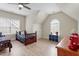 Bright, airy bedroom featuring twin beds, a ceiling fan, light hardwood floors, and a charming arched window at 5102 Highcroft Dr, Cary, NC 27519