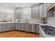 Modern kitchen with stainless steel appliances, gray cabinets, and hardwood floors at 5102 Highcroft Dr, Cary, NC 27519