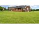 Wide shot of the backyard with a brick home and back patio at 5136 Liberty Grove Rd, Liberty, NC 27298