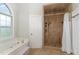 Spa-like bathroom features tiled shower, soaking tub, and natural light from window at 5136 Liberty Grove Rd, Liberty, NC 27298