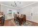 Light-filled dining room with a wooden table and bench, and French doors to the backyard at 5136 Liberty Grove Rd, Liberty, NC 27298