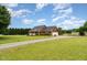 Expansive home with a long driveway, three-car garage and pool, surrounded by lush greenery at 5136 Liberty Grove Rd, Liberty, NC 27298