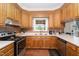 Sunlit kitchen features wood cabinets, tiled backsplash, updated appliances, and stainless dishwasher at 5136 Liberty Grove Rd, Liberty, NC 27298