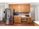 Kitchen with stainless refrigerator, microwave, wood cabinets, and view to living space at 5136 Liberty Grove Rd, Liberty, NC 27298