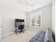 Cozy bedroom featuring a window, neutral carpet, futon, desk, and a ceiling fan at 524 Rowanwood Way, Apex, NC 27523