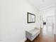 Light and airy hallway featuring hardwood floors, neutral walls, and a sitting bench at 524 Rowanwood Way, Apex, NC 27523