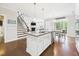 Open-concept kitchen flows to the Gathering room and features stainless steel appliances, granite counters, and center island at 524 Rowanwood Way, Apex, NC 27523