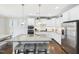 Kitchen features stainless steel appliances, a large center island with seating, and white cabinets at 524 Rowanwood Way, Apex, NC 27523