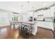 Bright eat-in kitchen featuring a large island with granite counters, white cabinets, and stainless steel appliances at 524 Rowanwood Way, Apex, NC 27523