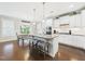 Bright eat-in kitchen featuring a large island with granite counters, white cabinets, and stainless steel appliances at 524 Rowanwood Way, Apex, NC 27523
