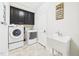 Well-equipped laundry room with a sink, washer, dryer, storage, and tile floors at 524 Rowanwood Way, Apex, NC 27523