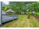 The backyard boasts a gazebo, deck, mature trees, lush grass, and a play area at 5409 Knollwood Rd Rd, Raleigh, NC 27609