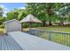 This backyard has a wooden gazebo with a deck, mature trees, lush grass, and a play area at 5409 Knollwood Rd Rd, Raleigh, NC 27609