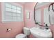 Quaint powder room featuring pink walls and a pedestal sink at 5409 Knollwood Rd Rd, Raleigh, NC 27609