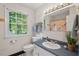 Cozy bathroom with a classic vanity, floral shower curtain, and a bright window with view to the outdoors at 5409 Knollwood Rd Rd, Raleigh, NC 27609