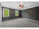 Spacious bedroom with grey walls, plush carpet, and two bright windows at 5409 Knollwood Rd Rd, Raleigh, NC 27609