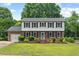 Charming two-story brick home with black shutters, a manicured lawn, and beautiful landscaping at 5409 Knollwood Rd Rd, Raleigh, NC 27609