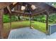 View of the gazebo interior with a ceiling fan, lighting, and views of the backyard play area and greenery at 5409 Knollwood Rd Rd, Raleigh, NC 27609
