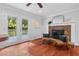 Bright living room showcasing hardwood floors, a brick fireplace, and access to the outdoor deck at 5409 Knollwood Rd Rd, Raleigh, NC 27609