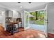 Living room with hardwood floors, mini bar, and an open door leading to the backyard patio at 5409 Knollwood Rd Rd, Raleigh, NC 27609