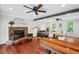 Bright living room featuring hardwood floors, ceiling fan, brick fireplace, and comfortable seating at 5409 Knollwood Rd Rd, Raleigh, NC 27609