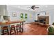 Inviting living room featuring hardwood floors, brick fireplace, and bar with seating at 5409 Knollwood Rd Rd, Raleigh, NC 27609