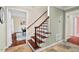 Elegant staircase with hardwood steps, a decorative banister, and an entrance to the dining room at 5409 Knollwood Rd Rd, Raleigh, NC 27609