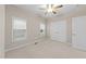 Neutral bedroom with multiple windows, fan, plush carpet and a closet with white bi-fold doors at 5644 Wade Park Blvd, Raleigh, NC 27607