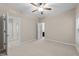 Neutral bedroom with plush carpet, ceiling fan, and connecting hallway and bath at 5644 Wade Park Blvd, Raleigh, NC 27607
