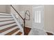 Elegant foyer showcasing hardwood floors, staircase with white railing, and a stylish front door at 5644 Wade Park Blvd, Raleigh, NC 27607
