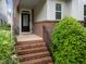 Inviting front porch with brick steps, black railings, and views of the lovely landscaping at 5644 Wade Park Blvd, Raleigh, NC 27607