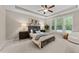 The main bedroom offers a ceiling fan and many windows that provide ample natural light at 5644 Wade Park Blvd, Raleigh, NC 27607