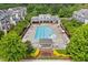Aerial view of the community pool with chairs and clubhouse surrounded by mature trees and townhomes at 5644 Wade Park Blvd, Raleigh, NC 27607